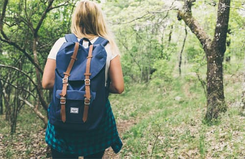 A young girl walking through woodland