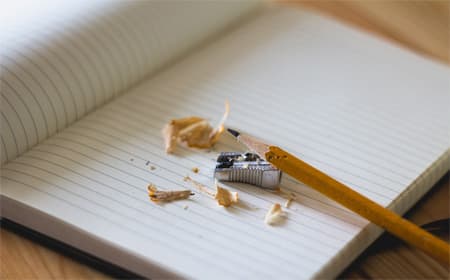 A pencil resting on a writing book